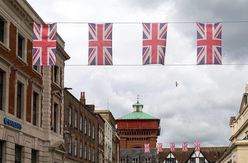 Union Jack bunting flags in a line strung across High Street in town centre of Colchester, Essex, England, UK