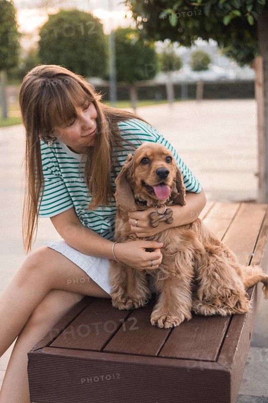 A woman embraces her dog lovingly on a bench, creating a warm atmosphere