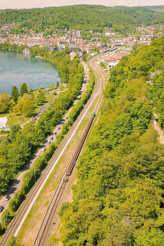 Aerial view of a city with river and railway lines, surrounded by lush forests, construction site by Leonhard Weiss to renovate the train station and build the overhead line, Waldshut, Germany