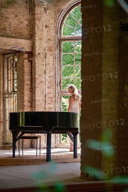 A woman stands at the wing in the former Grabowsee health resort, Lost Place, Oberhavel, Brandenburg, Germany