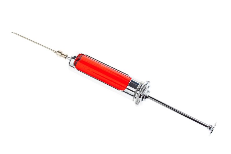 Injection needle and syringe against white background