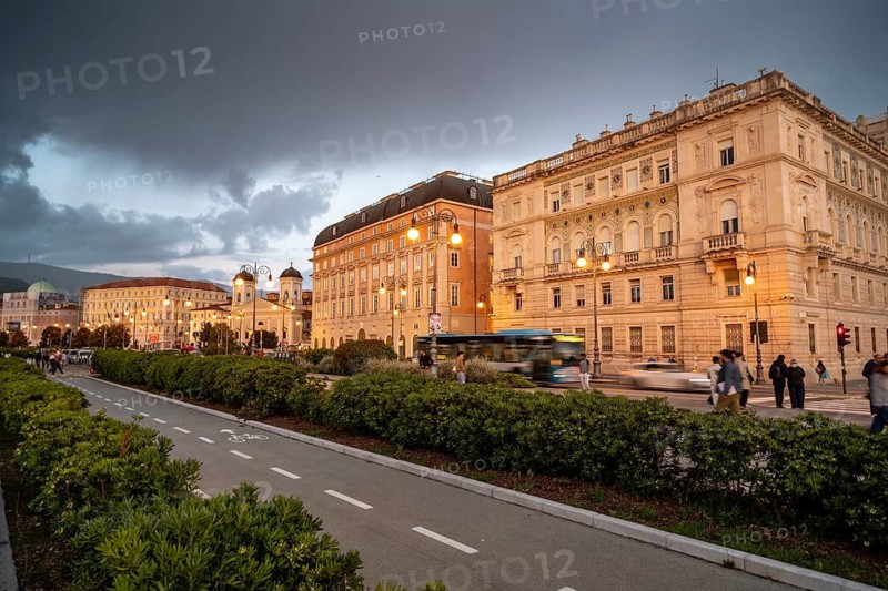 Magnificent buildings and palaces on the seafront Riva del Mandracchio, Palazzo della Luogotenenza Austriaca or Palazzo Governo, Greek Orthodox Church San Nicolò, dramatic clouds at sunset, Trieste, Friuli-Venezia Giulia region, Italy