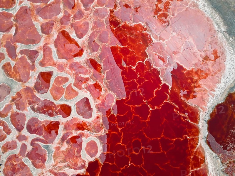 Aerial view of Ulan Lake, the ‘Red Lake', caused by microorganisms and algae such as Dunaliella salina, which produce the pigment beta-carotene to protect themselves from strong UV radiation, Ulan Lake (Ulan See), a salt lake in the Tengger Desert – part of the Gobi Desert known as the ‘red heart of the Earth' – in Inner Mongolia, China