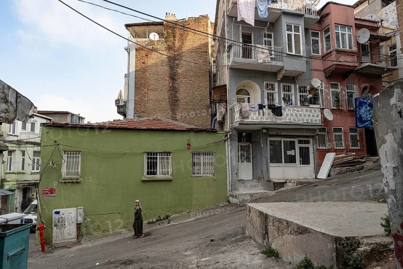 Istanbul, Turkey. August 8th 2026. A local woman walks past old houses in the Tarlabasi district of Istanbul, a culturally mixed neighbourhood known for its Kurdish, Romani and Transgender community currently undergoing extensive gentrification. Turkey