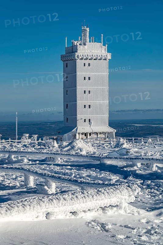 Weather station tower covered by snow and ice on the Brocken summit, on a sunny winter day under clear blue sky, Harz National Park, Saxony-Anhalt, Germany