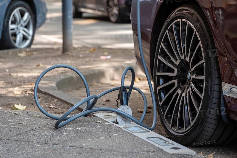 An e-car is charged with a cable at a charging curb on the KÖ, Düsseldorf, Germany