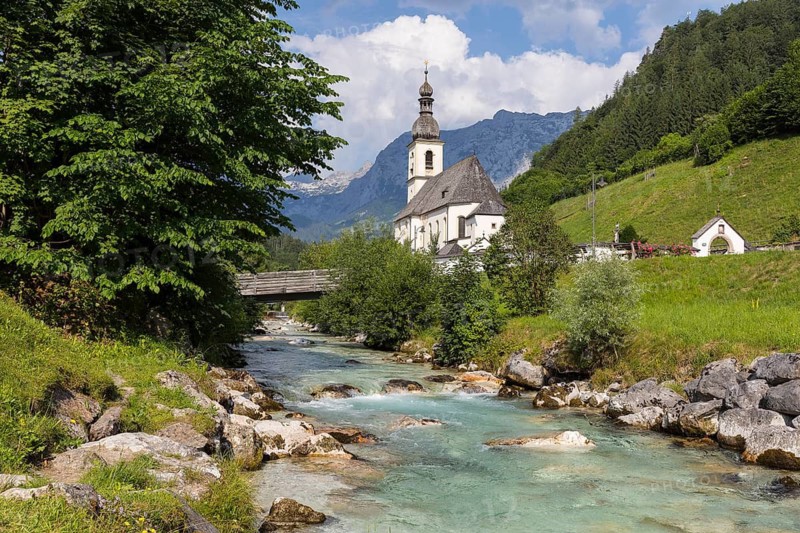 Famous view of the parish church of St. Sebastian with bridge over the Ramsauer Ache in the Ramsauer Malerwinkel with horse-rider Alm and Wagendrischelhorn, Ramsau near Berchtesgaden, Berchtesgadener Land, Bavaria, Germany