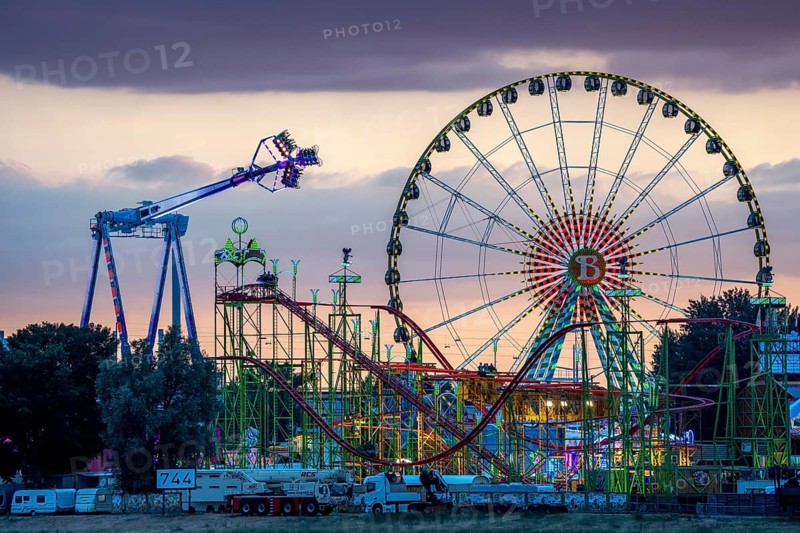 Rhine fair in the Rheinwiesen in Düsseldorf-Oberkassel, rides in the evening, with lots of lighting, Ferris wheel, infinity, world's largest mobile overhead swing, Wilde Maus rollercoaster, North Rhine-Westphalia, Germany