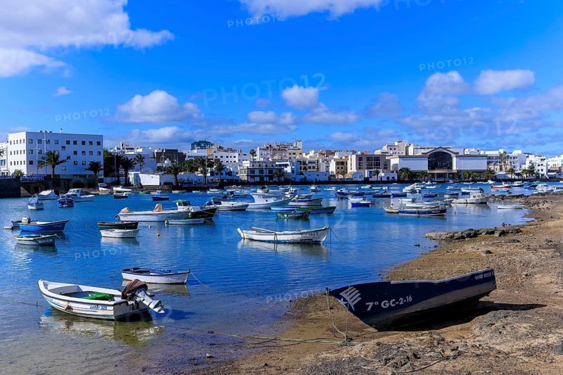 Lanzarote, Canary Islands, Spain, Europe, Charco San Gines harbour area in Arrecife, boats lying on the edge of a harbour, white buildings of a coastal town in the background