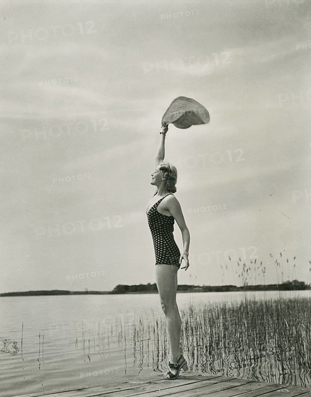 Irene von Meyendorff, actress, film scene, Tobis film art, farewell, woman in a bathing suit on the lakeside, raising her hat in vintage photography of the free moment, photo Sandau Junior, around 1935