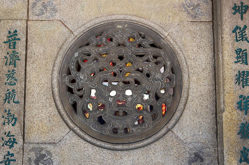 Carved stone medallion and inscribed pillar of traditional Chinese relief carving and calligraphy on the temple's stone wall, Thian Hock Keng Temple, Singapore