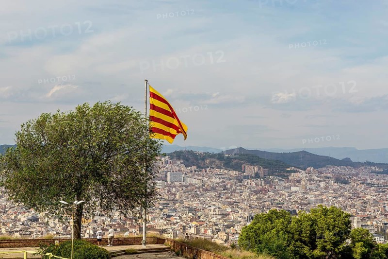 Catalan flag flies over the Montjuic Castle old military fortress on Montjuic Mountain overlooking the city, Barcelona, Spain