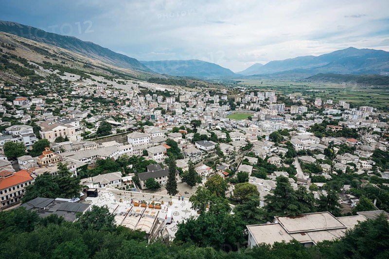 GJIROKASTER, ALBANIA - JUNE 30, 2026: Panoramic aerial view of the historic town of Gjirokaster with traditional stone houses surrounded by green hills and mountains