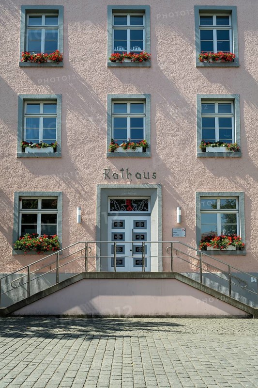 Façade of the town hall, flower boxes with geraniums in front of the windows, symmetry, Soest, Westphalia, North Rhine-Westphalia, Germany