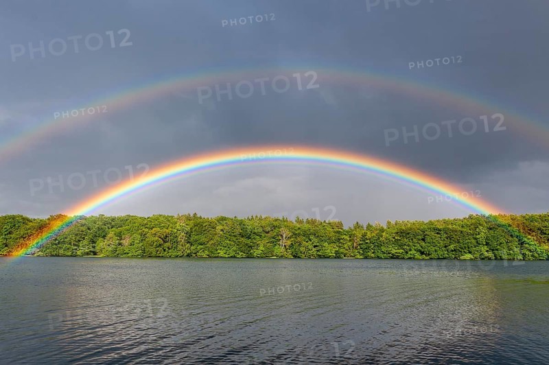 Colored rainbow over a lake, in Müritz National Park, Feldberger Seenlandschaft, Mecklenburg-Western Pomerania, Germany