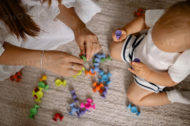 A mother and child play with colorful toys together, sharing a moment of joy and interaction