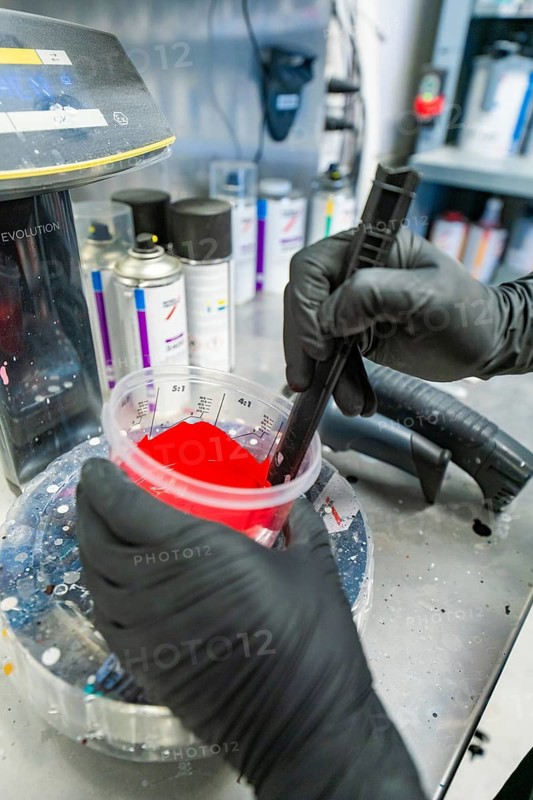 Preparation of red paint in the workshop by a person with black gloves, painter, Calw, Germany