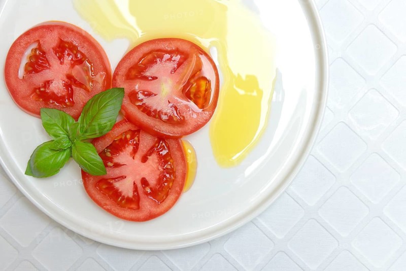 Sliced tomatoes on plate with olive oil