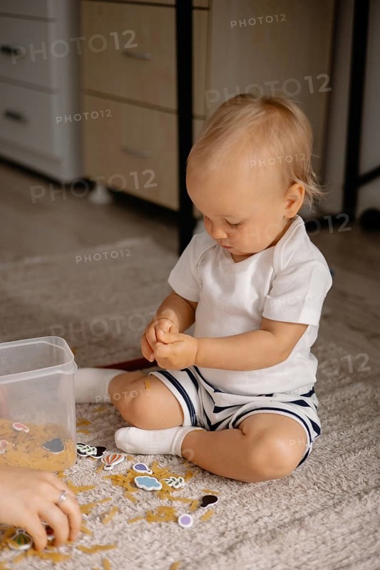 A young child intently examines stickers, showcasing a moment of concentration