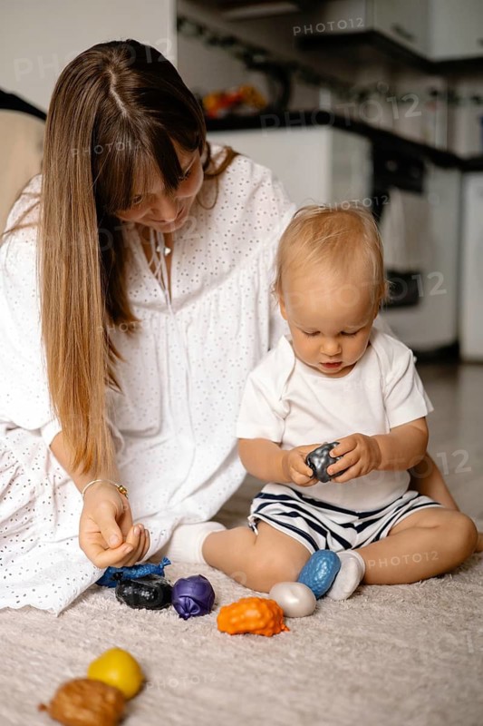 Mother and baby playing with toys together on the floor