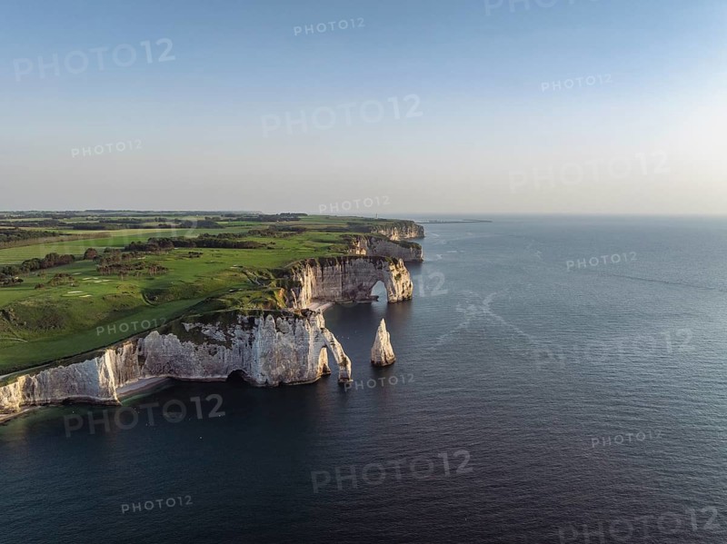 Aerial view of the Porte d'Aval rock formation in the evening sun, well-known sights on the chalk coast with the distinctive rock pin, behind it the La Manneporte rock formation and the Pointe de la Courtine ledge, then Pointe du Fourquet, right on the cliffs the Golf d'Étretat golf course founded in 1908, Alabaster Coast, La Côte d'Albâtre, chalk cliffs, English Channel, Seine-Maritime, Normandie, France