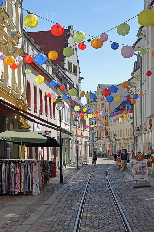 Decoration with colorful lanterns, balloons, pedestrians, railroad tracks, Bäckerstraße, Döbeln, Saxony, Germany