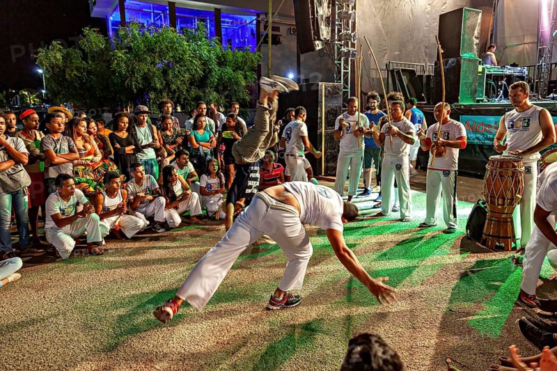 Capoeira dancers perform acrobatic movements at night, accompanied by drummers and spectators, The Capoeira battle dance at a small festival in Petrolina Brazil