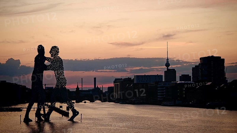 Molecule man, molecule men, sculpture, figures in the water of the Spree against an impressive evening sky, television tower in the background, urban environment, sunset, Berlin
