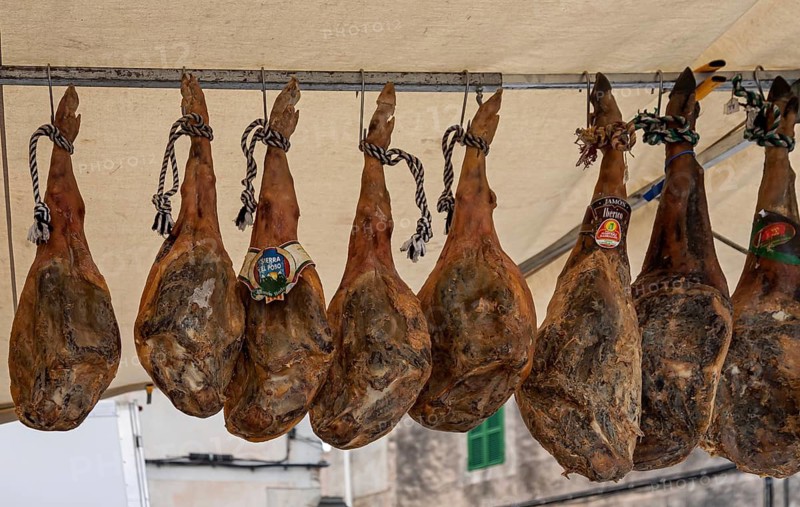 Sales stand with whole pork ham, farmers market, weekly market market, Sineu, Majorca, Spain
