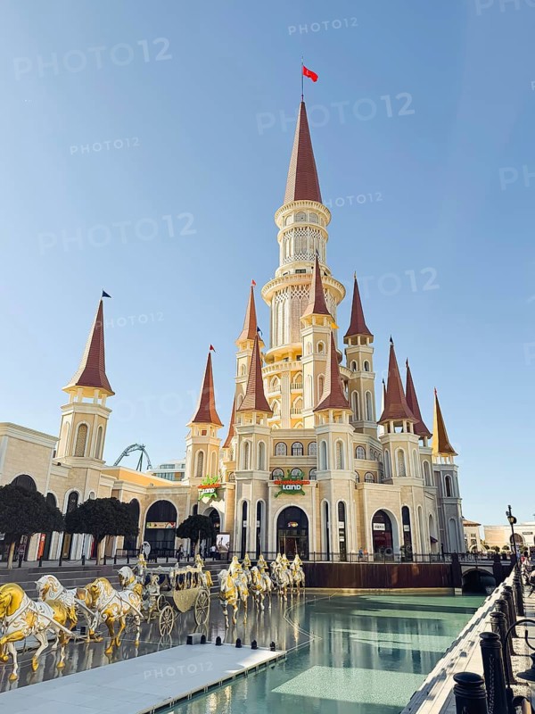 Belek, Antalya, Turkiye - March 12, 2025. The Land of Legends theme park in Belek, Turkiye. View toward the Chateau building, with a pool and chariot monument
