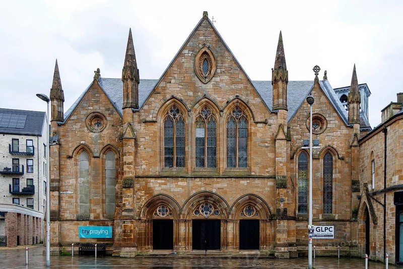 Triple gabled sandstone facade of Govan and Linthouse Parish Church, a Gothic revival building at Govan Cross, Glasgow, Scotland, United Kingdom