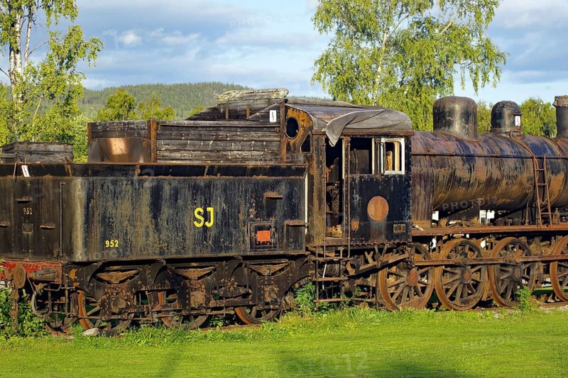 Old, rusty steam locomotive on rails in rural area with trees, Inlandsbanan, Inlandsbahn, Sweden