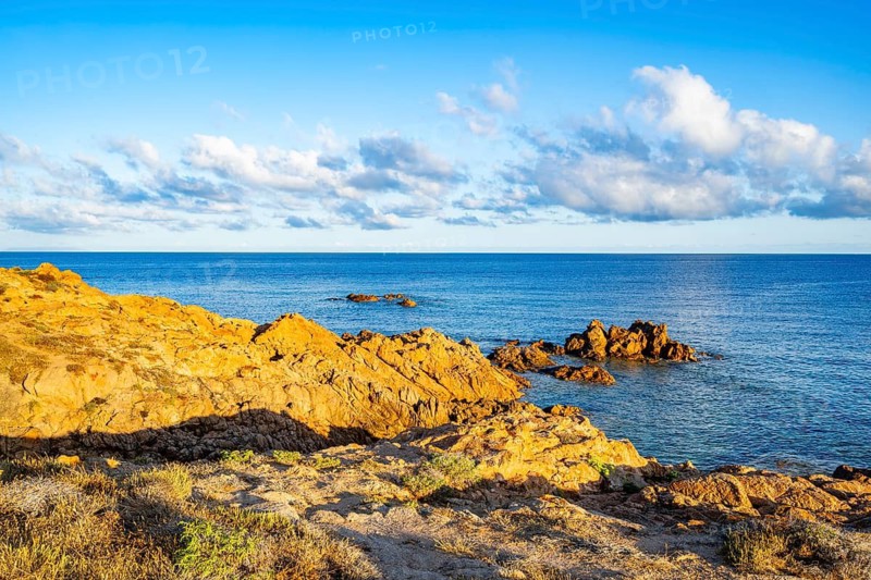 Landscape of the coastline with blue water at Marinedda Coast at sunset, Sardinia, Italy
