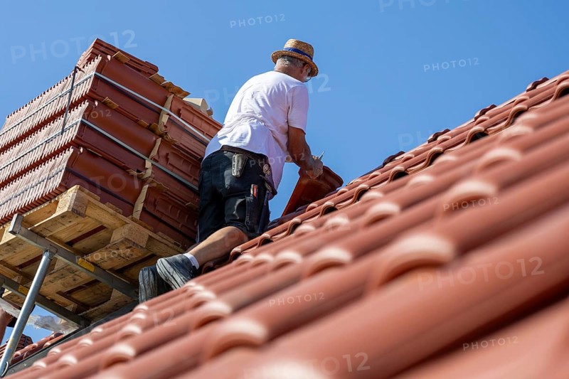 Carpenter or roofer covering a tiled roof in the Palatinate. The temperatures rise to over 35 degrees on this day