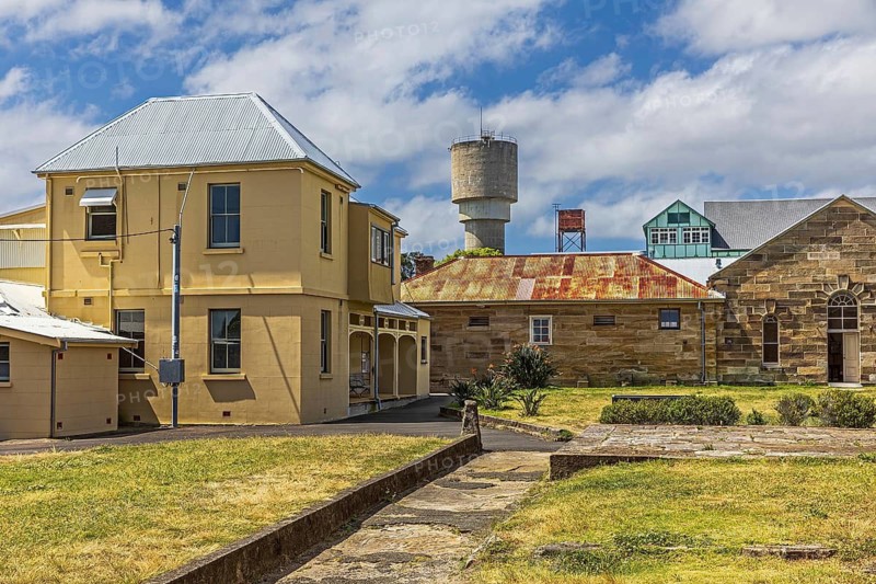 Several buildings in the historic convict precinct in front of Cockatoo Island power station water tower, Cockatoo Island, Sydney, Australia