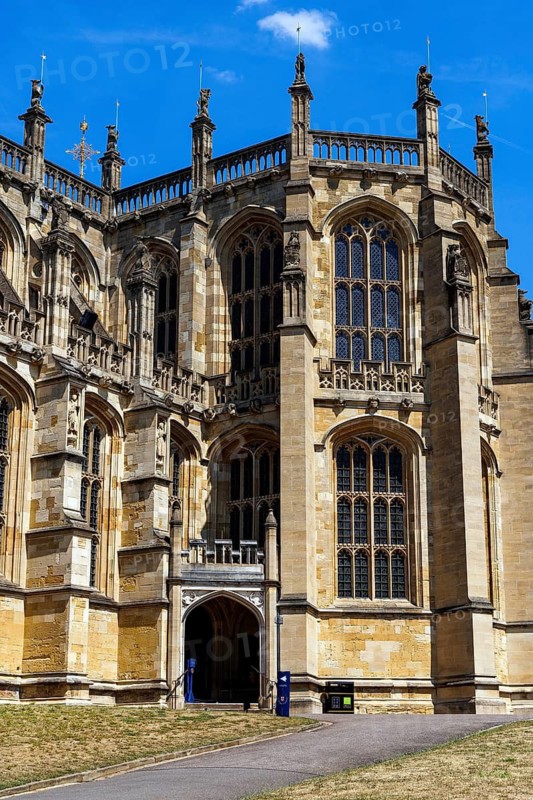 Statue niches and slender pinnacles crown the corner buttresses at St George's Chapel, with a canopied entrance below leading into the Perpendicular Gothic chapel that has served as a royal burial place since the fifteenth century, Windsor, England, United Kingdom