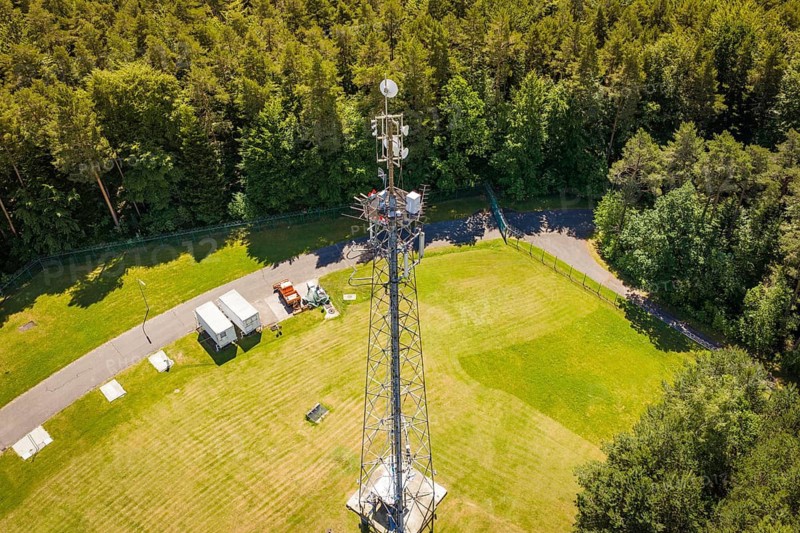 A radio tower in the middle of meadows and forest next to a small road, bunker complex, Calw, Germany