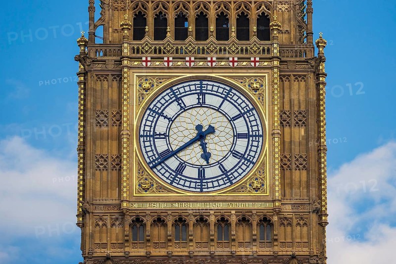 The ornate gilded clock face of the Elizabeth Tower stands out against a blue sky at the Houses of Parliament, London, England, United Kingdom