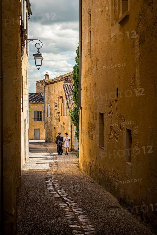 A couple strolling through the old town alleys of Saint Emilion, France