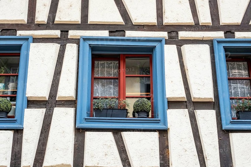 Detailed view of a half-timbered house with blue window frames and flower decoration in the old town of Radolfzell