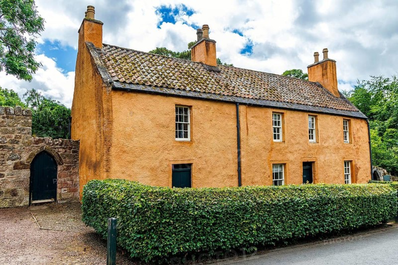 College Hill House, once the Old Rosslyn Inn, stands behind a hedge in Roslin village, Midlothian, Scotland, United Kingdom