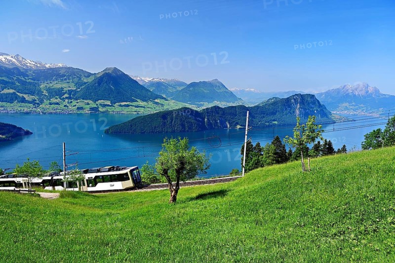 Vitznau Rigi Railway modern grey articulated railcar, behind Lake Lucerne with Buochserhorn, Bürgenstock, Stanserhorn, Pilatus, Vitznau, Canton of Lucerne, Switzerland