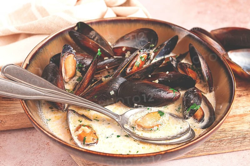Mussels in creamy garlic sauce, served with fresh herbs and spices, homemade, no people