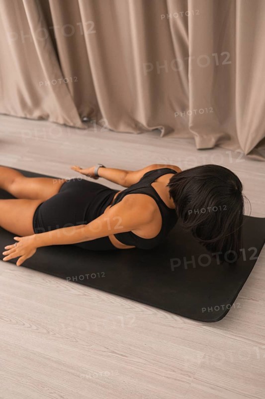 Woman practicing yoga pose on mat with a calm and focused atmosphere