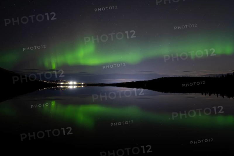 The Northern Lights (Aurora borealis) reflected in a forest lake, Gällivare, Norrbotten, Lapland, Sweden, October 2023
