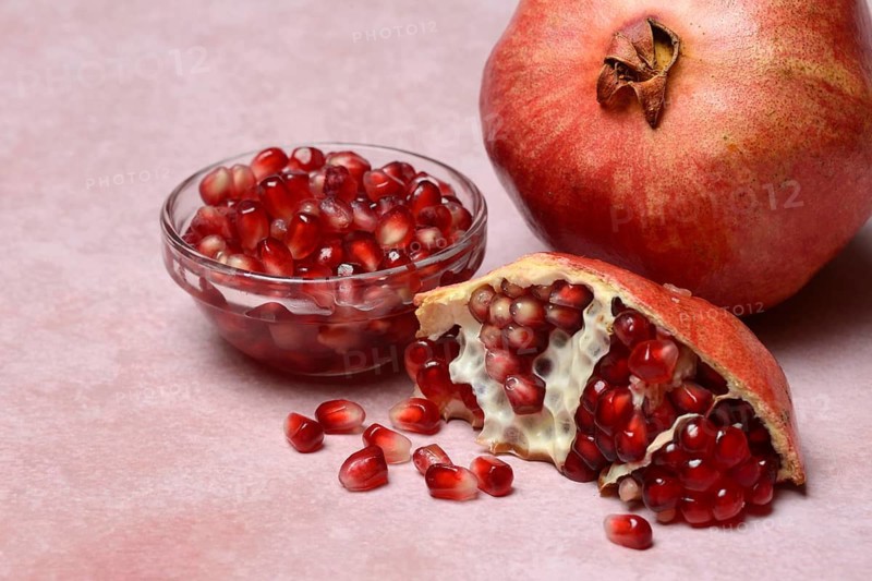 Opened pomegranate and pomegranate seeds in skin, Punica granatum