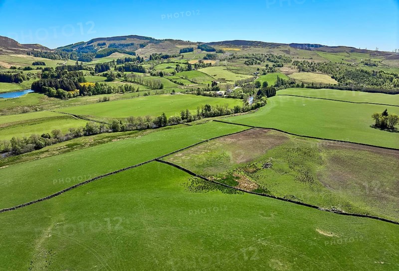 Aerial drone photo of agricultural landscape with meadows and pastures at the border of the Cairn Gorm National Park, Scotland, UK