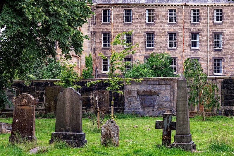 Weathered gravestones Gravestones in historic burial ground near Glasgow Royal Infirmary with the old nurses home behind, Glasgow, Scotland, United Kingdom