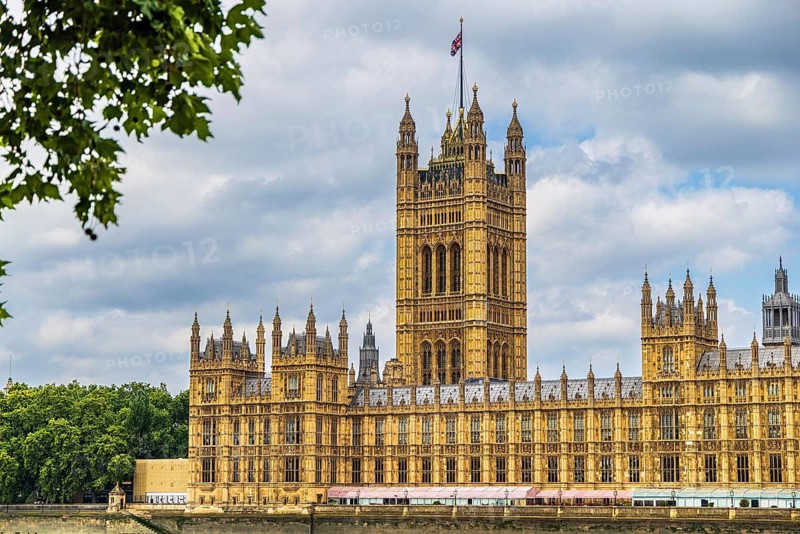 Victoria Tower, completed in 1860 as the tallest element of the Palace of Westminster, stands above the parliamentary rooftops. Designed by Charles Barry and Augustus Pugin, it originally housed the parliamentary archives and contains the Sovereigns Entrance, London, England, United Kingdom
