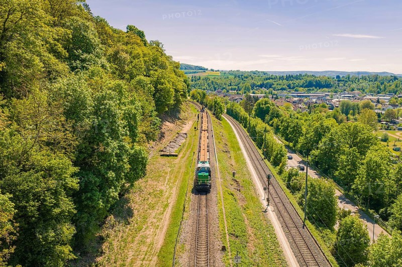 Green, hilly landscape with rails and a train, lined with trees and vegetation, electrification of the Hochrheinbahn, conversion of the railway station, Waldshut, Tiengen, Germany